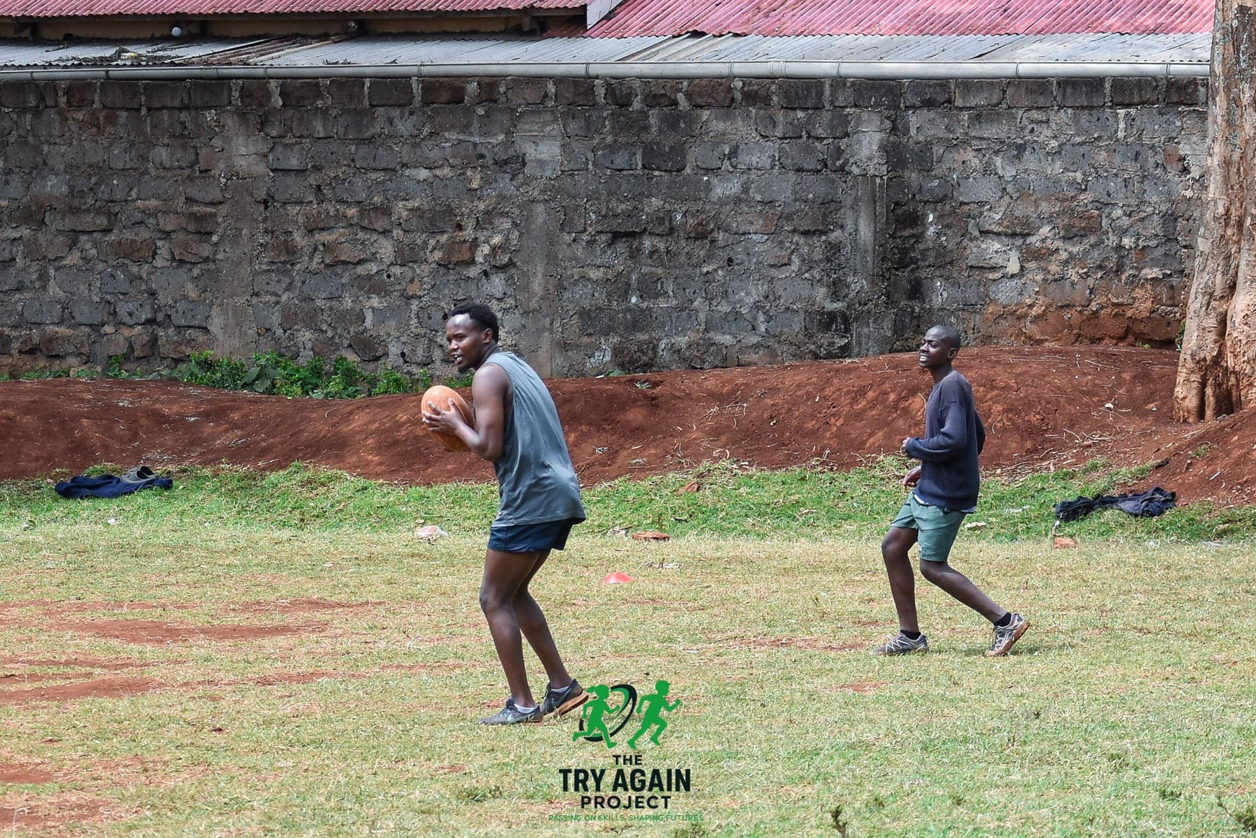 A player carrying the ball forward in open play while a teammate runs a supporting line behind him.