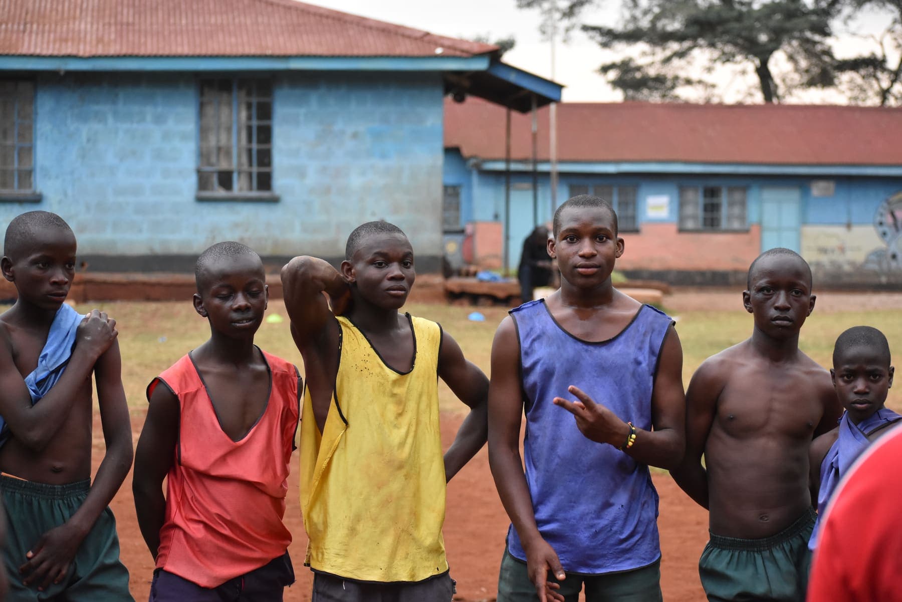 Players in training bibs standing together on the pitch, one gesturing as they wait for a drill to begin.